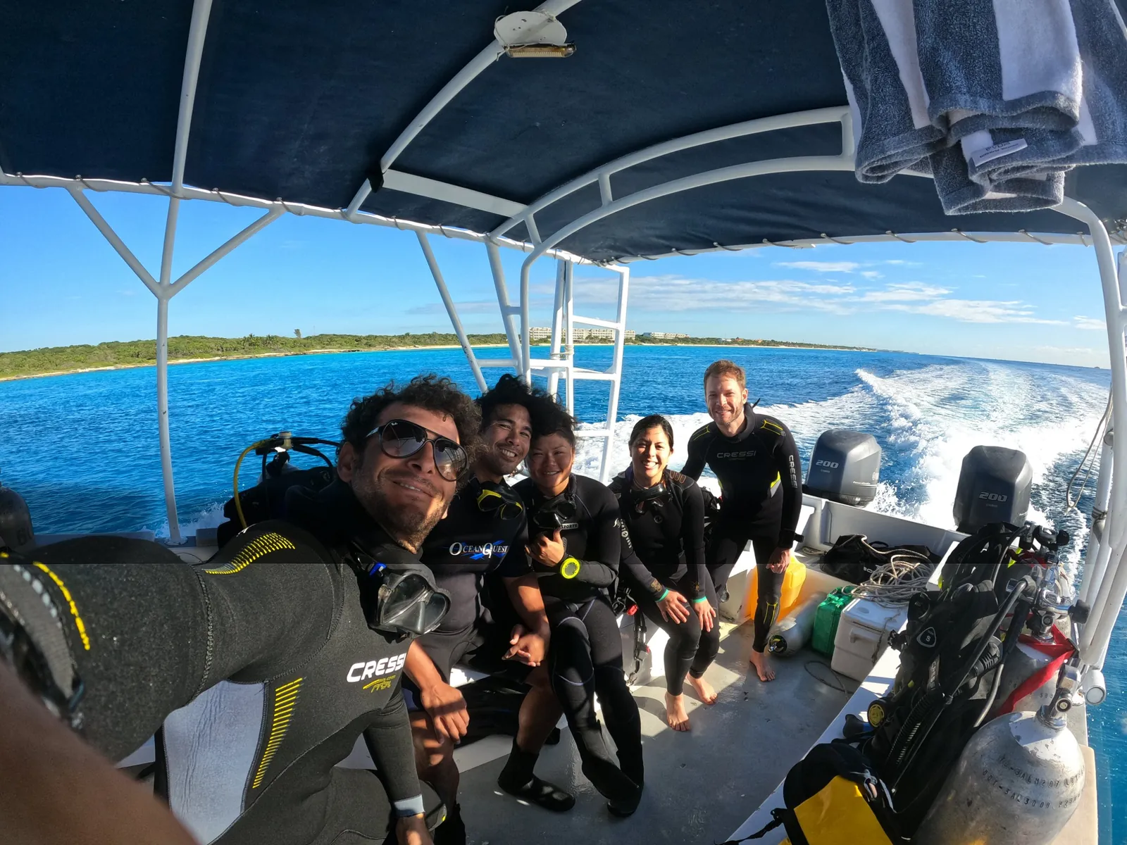 Grupo de buzos sonriendo en la lancha rápida de Playa del Carmen a Cozumel